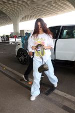 Disha Patani with sunglasses on wearing Sailor Moon Tee and Urban Renewal Vintage Overdyed French wind pant holding canon eos camera bag with New Balance Vinted Shoes